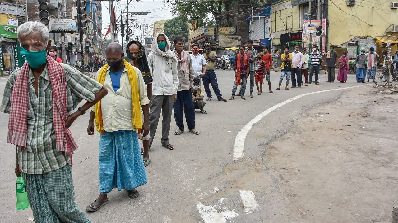 Needy people stand in a long queue outside Covid-19 relief camp for food, during Covid-induced total lockdown in Patna, Tuesday, May 11, 2021. Credit: PTI Photo