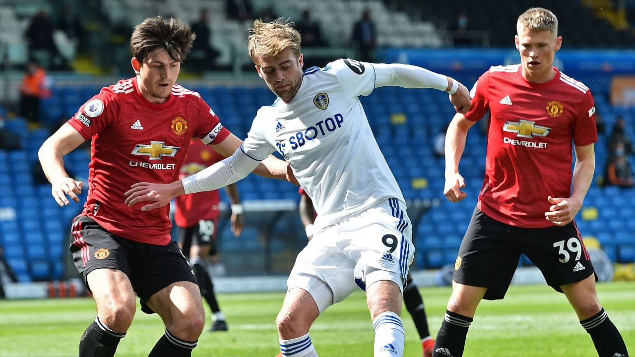 Leeds United's English striker Patrick Bamford (C) vies with Manchester United's English defender Harry Maguire (L). Credit: AFP Photo