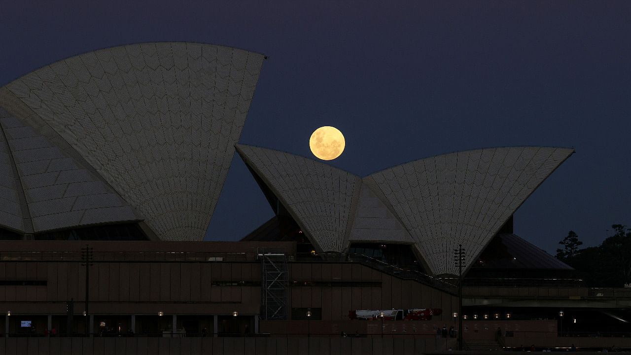 A Super Flower Moon rises behind the Sydney Opera House on the night of a lunar eclipse. Credit: Reuters Photo