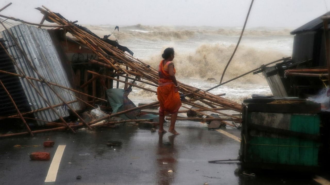 A woman stands next to her stall damaged by heavy winds at a shore ahead of Cyclone Yaas in Bichitrapur in Balasore district in the eastern state of Odisha India, May 26, 2021. Credit: Reuters Photo