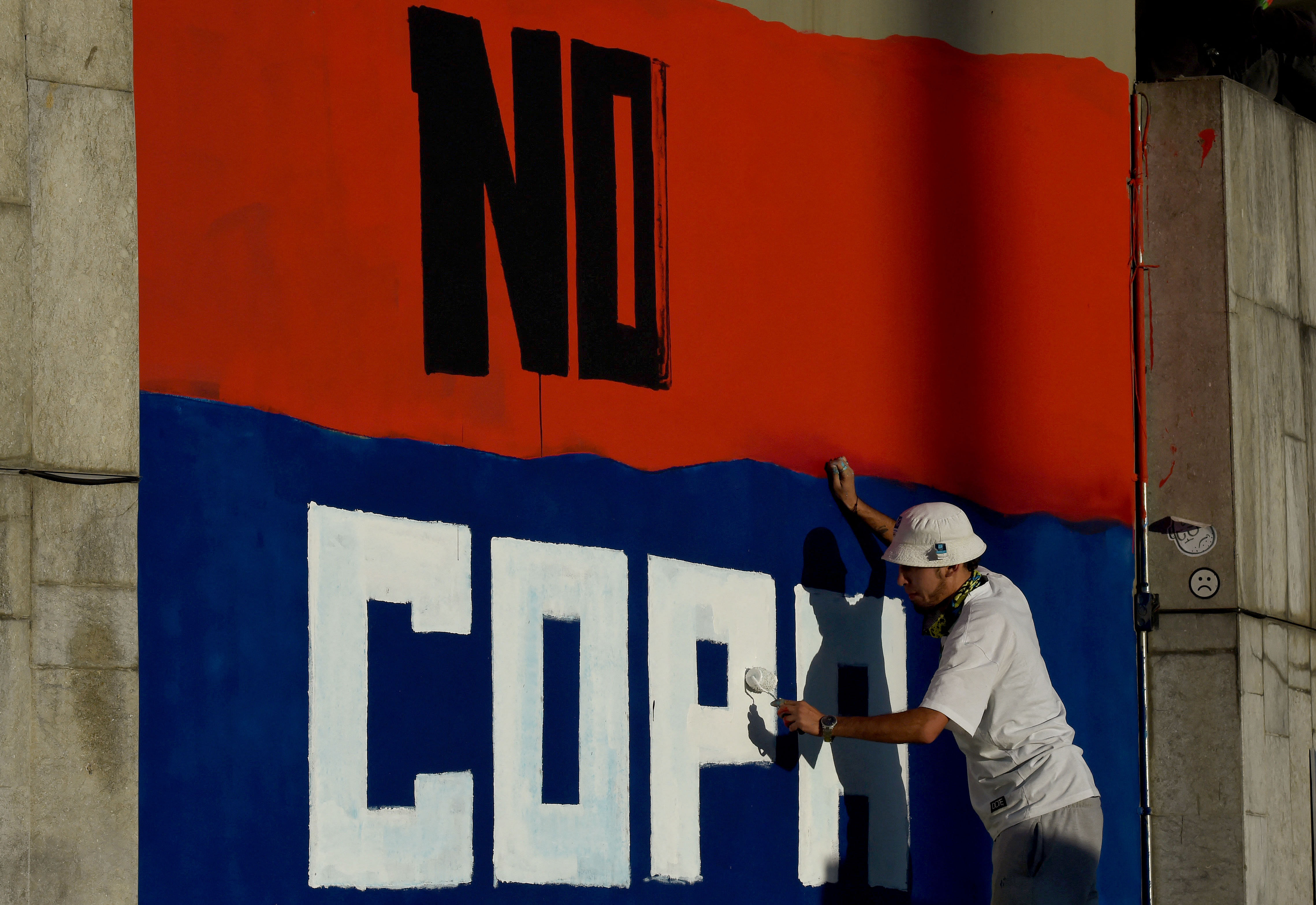 Street artists paint a graffiti reading 'No Copa America' at a wall of the Campin Stadium during a protest against Colombia hosting the Copa America soccer tournament in Bogota. Credit: AFP Photo