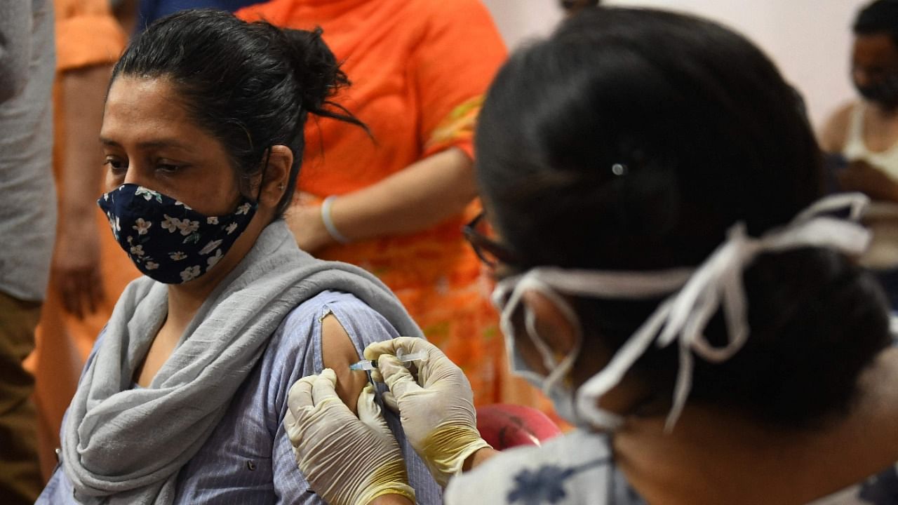 A health worker inoculates a woman with a dose of the Covaxin Covid-19 vaccine. Credit: AFP Photo