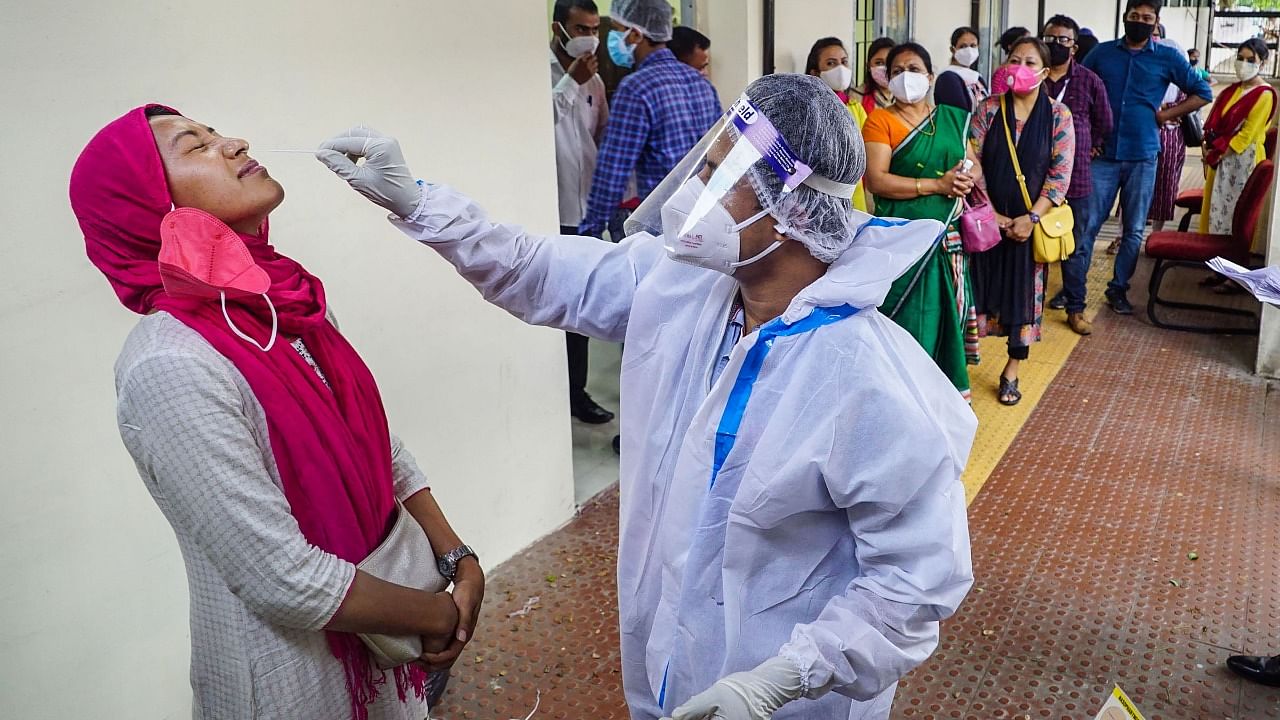 A health worker takes a swab sample of an employee of the Assam state Assembly for a Covid-19 test. Credit: PTI File Photo