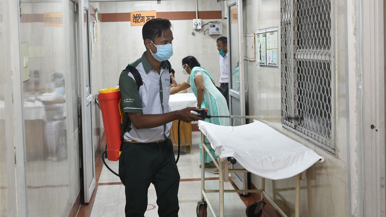 A man sprays sanitiser as a precaution against Covid-19 spread, at Civil Hospital in Lucknow. Credit: PTI Photo