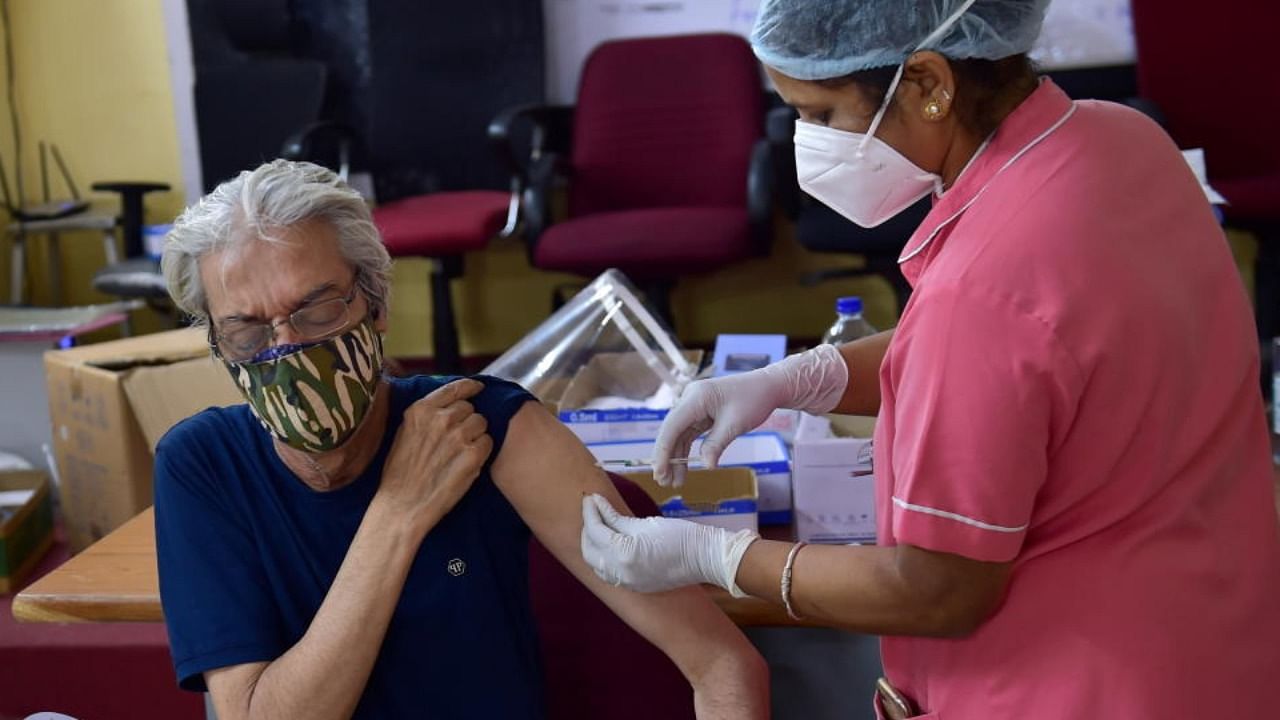 A medical officer gives a dose of Covid-19 vaccine to an old man, at a vaccination centre in Bengaluru. Credit: PTI Photo