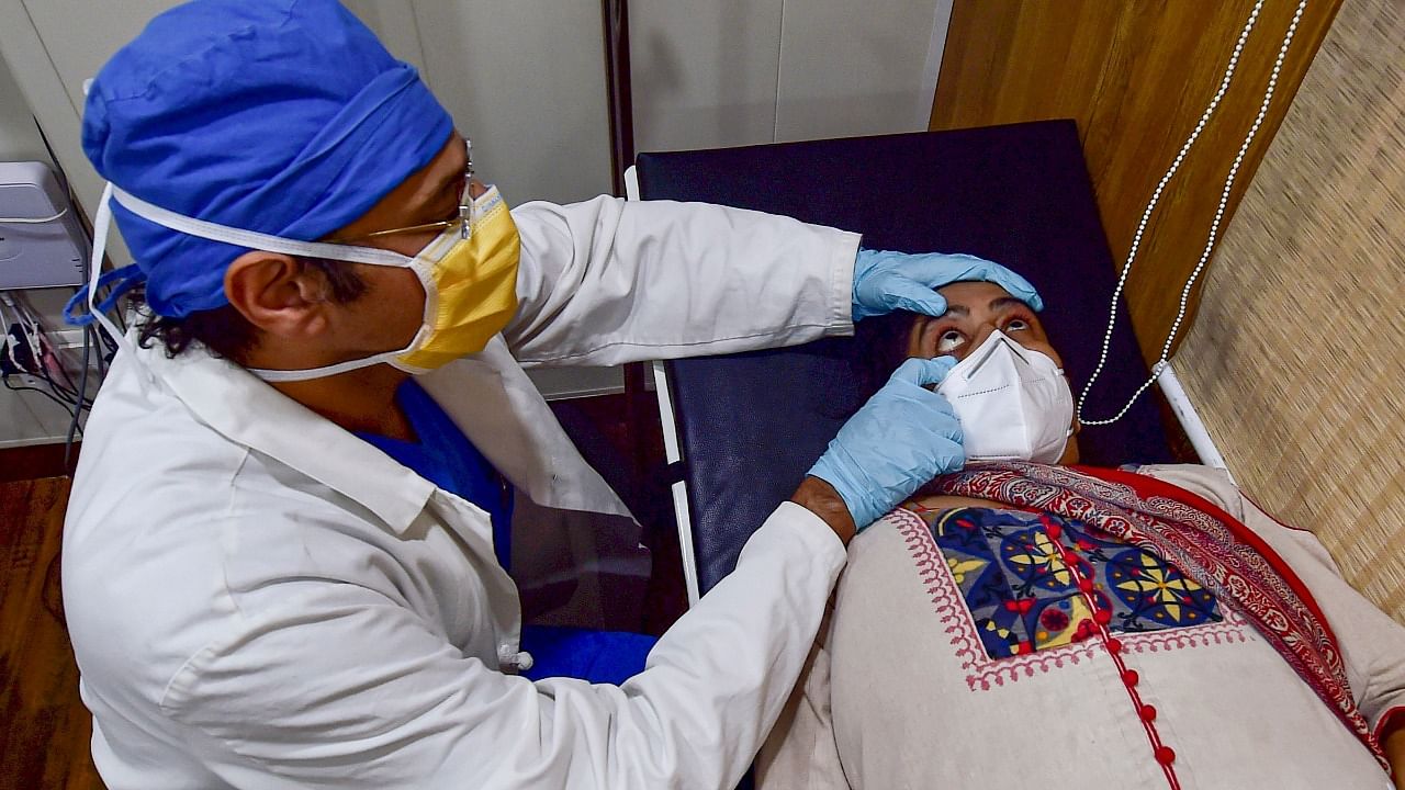 Dr. Ushast Dhir, Senior Consultant of Department of Surgical Gastroenterology and Liver Transplantation at Sir Ganga Ram Hospital, examines a suspected patient infected with mucormycosis. Credit: PTI Photo