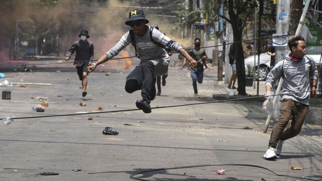 Anti-coup protesters run to avoid military forces during a demonstration in Yangon, Myanmar. Credit: AP Photo