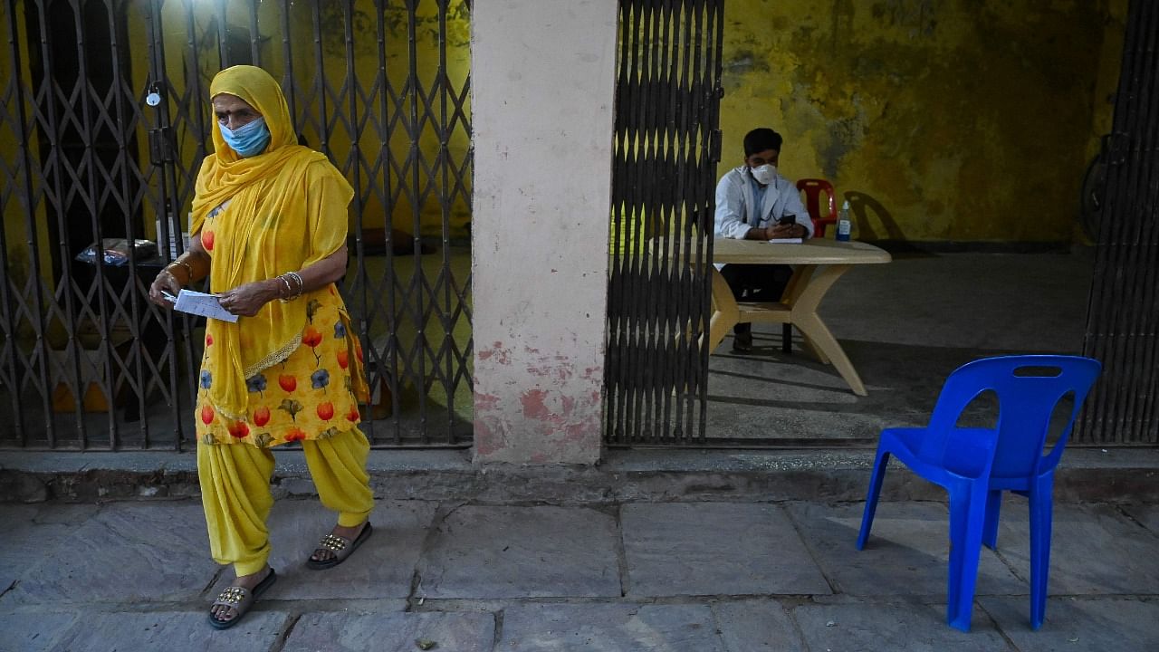 A patient with Covid-19 coronavirus symptoms leaves after a consultation with a volunteer doctor at a community centre temporarily used as an outpatient department, which is run by volunteers every afternoon for two hours to offer free healthcare, at Ghitorni village in New Delhi. Credit: AFP Photo