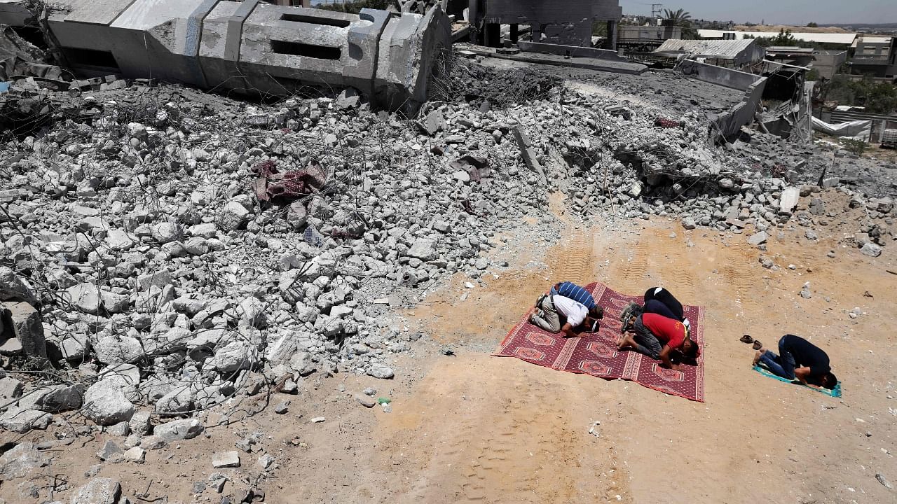 Palestinian Muslim worshippers pray near the rubble of a destroyed mosque in Beit Lahia, in the northern Gaza Strip. Credit: AFP Photo