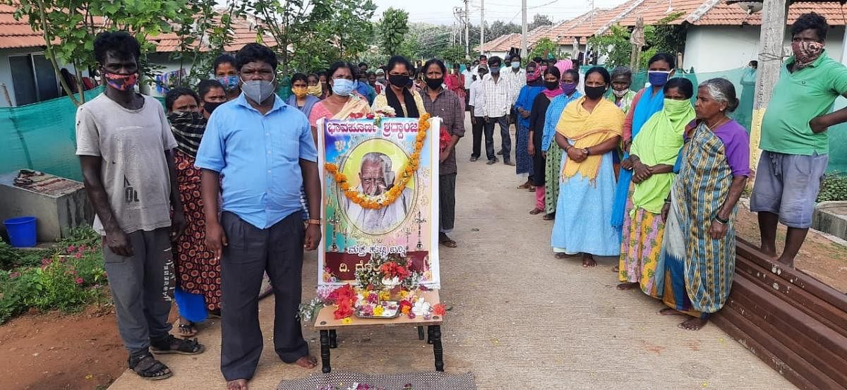 Residents of the rehabilitation site in Basavanahalli near Kushalnagar pay tributes to H S Doreswamy.