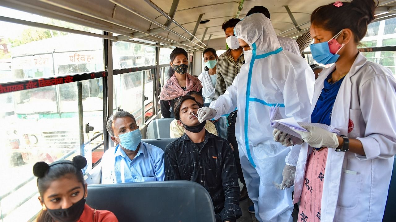 Medical workers conduct Covid-19 tests in a bus at Alambagh Bus Station in Lucknow. Credit: PTI File Photo