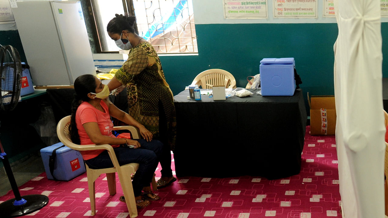 A medic inoculates a dose of a Covid-19 vaccine to a woman at the BMC school vacination centre, Kandivali East in Mumbai. Credit: PTI Photo