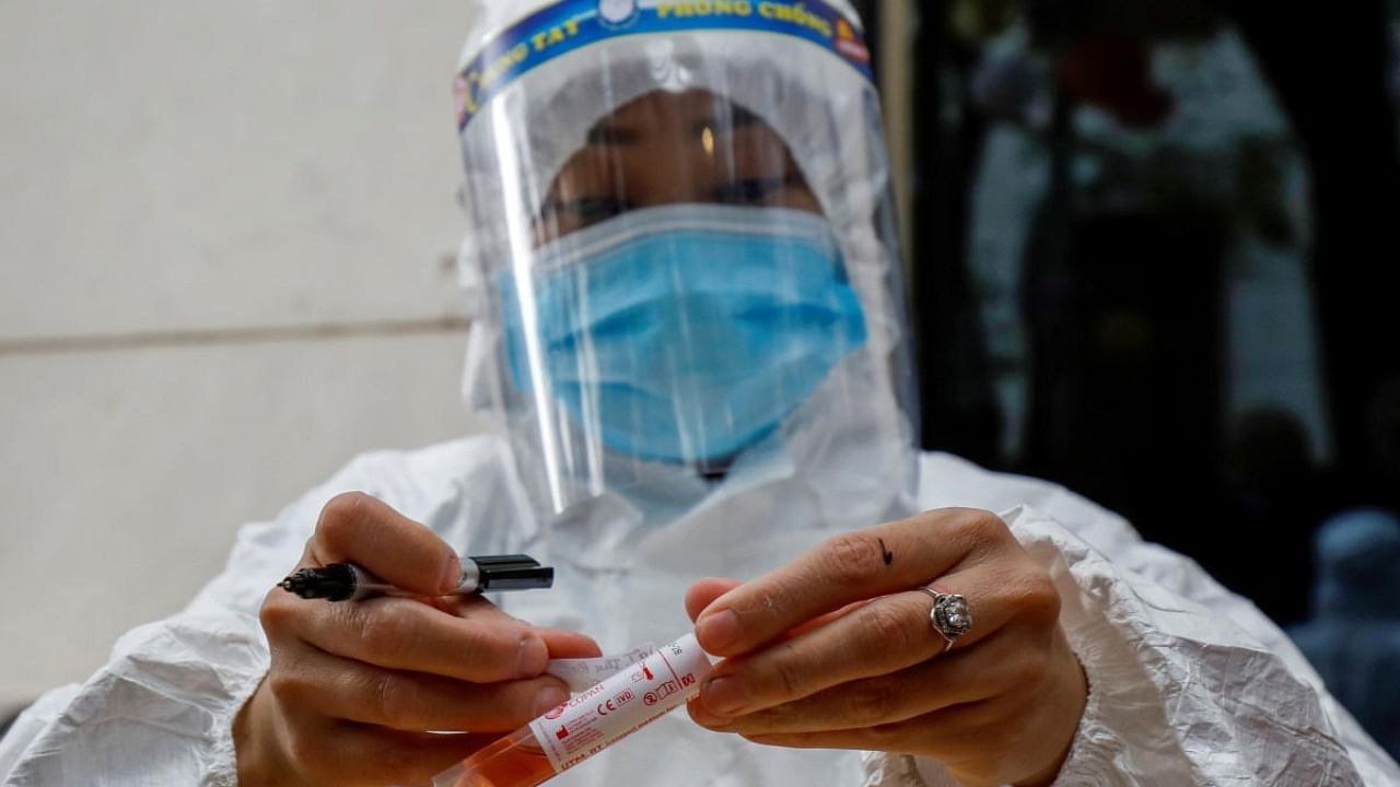  A health worker labels a test-sample tube during the coronavirus outbreak in Hanoi, Vietnam. Credit: Reutes Photo