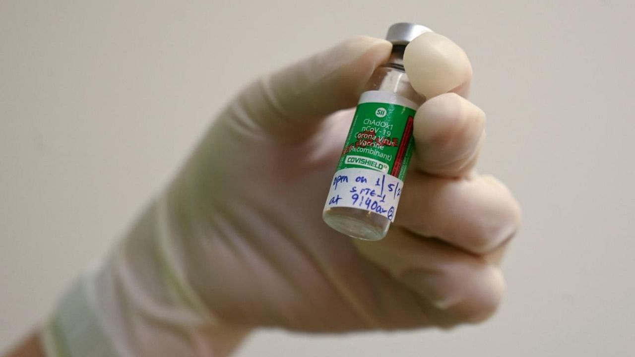 A medical worker holds a vial of the Covishield. Credit: AFP Photo