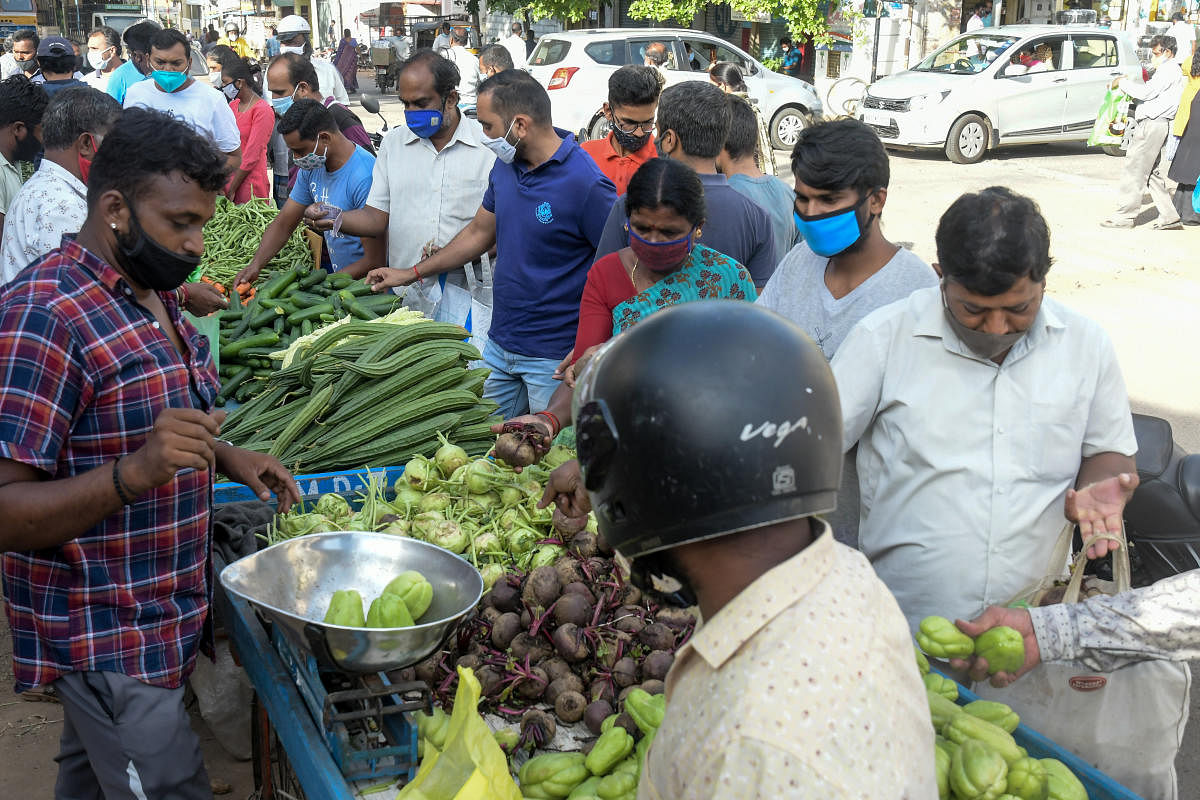 People buy vegetables and essential items, near Nanjumalige in Mysuru on Monday. DH PHOTO