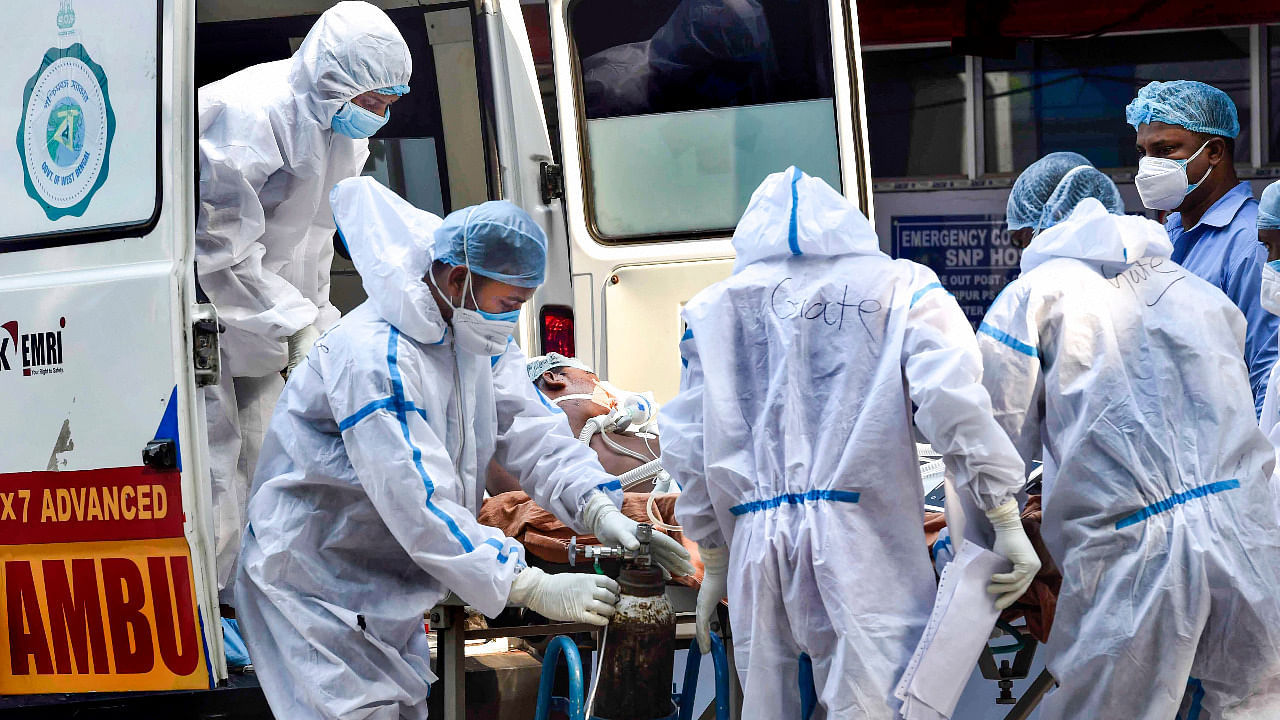 Health workers wearing PPE kit admit a Covid-19 patient at a government hospital, in Kolkata. Credit: PTI Photo