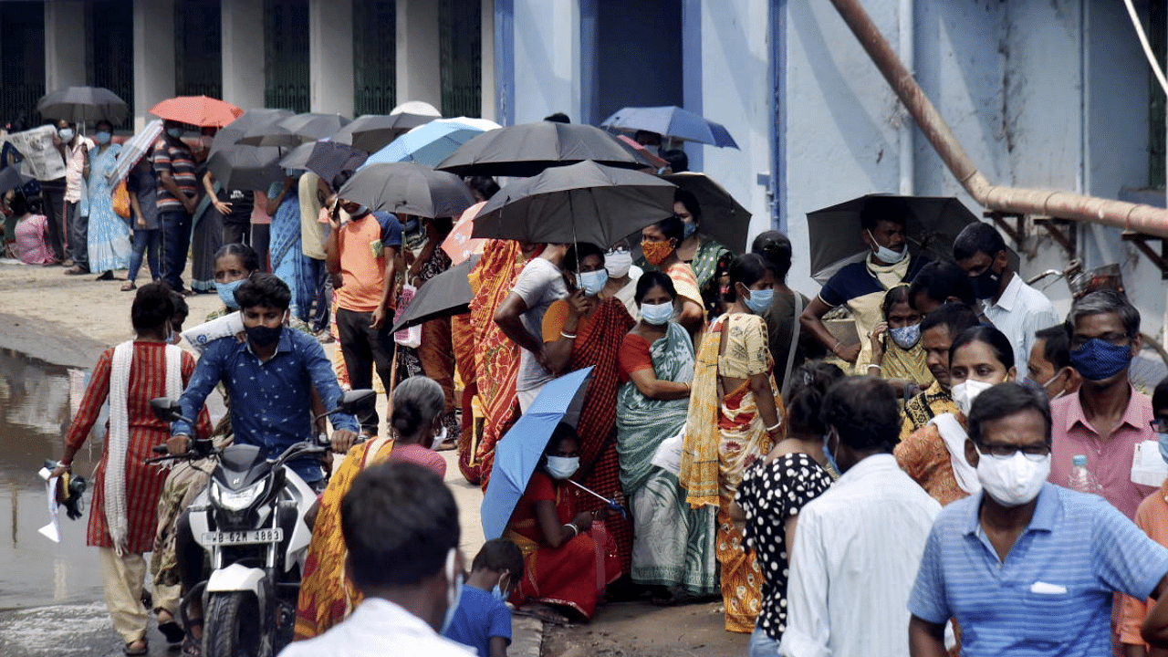 Beneficiaries, not adhering to social distancing norms, wait in a queue to receive the Covid-19 vaccine dose, at Balurghat in West Bengal. Credit: PTI Photo