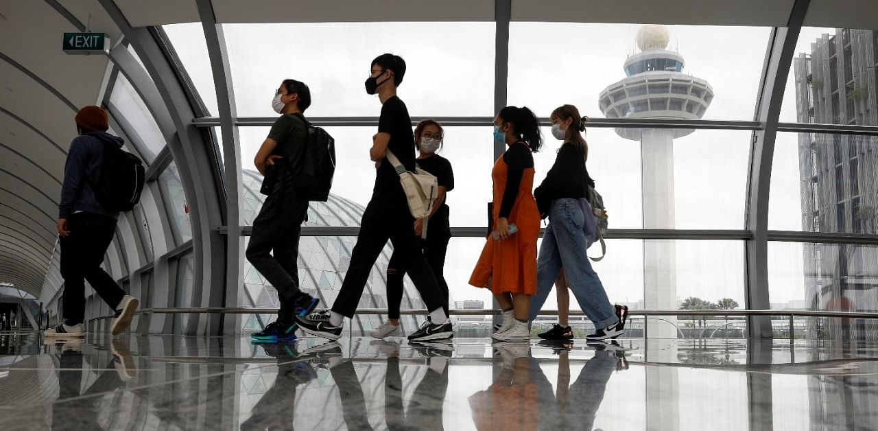 People pass the control tower of Singapore's Changi Airport. Credit: Reuters Photo