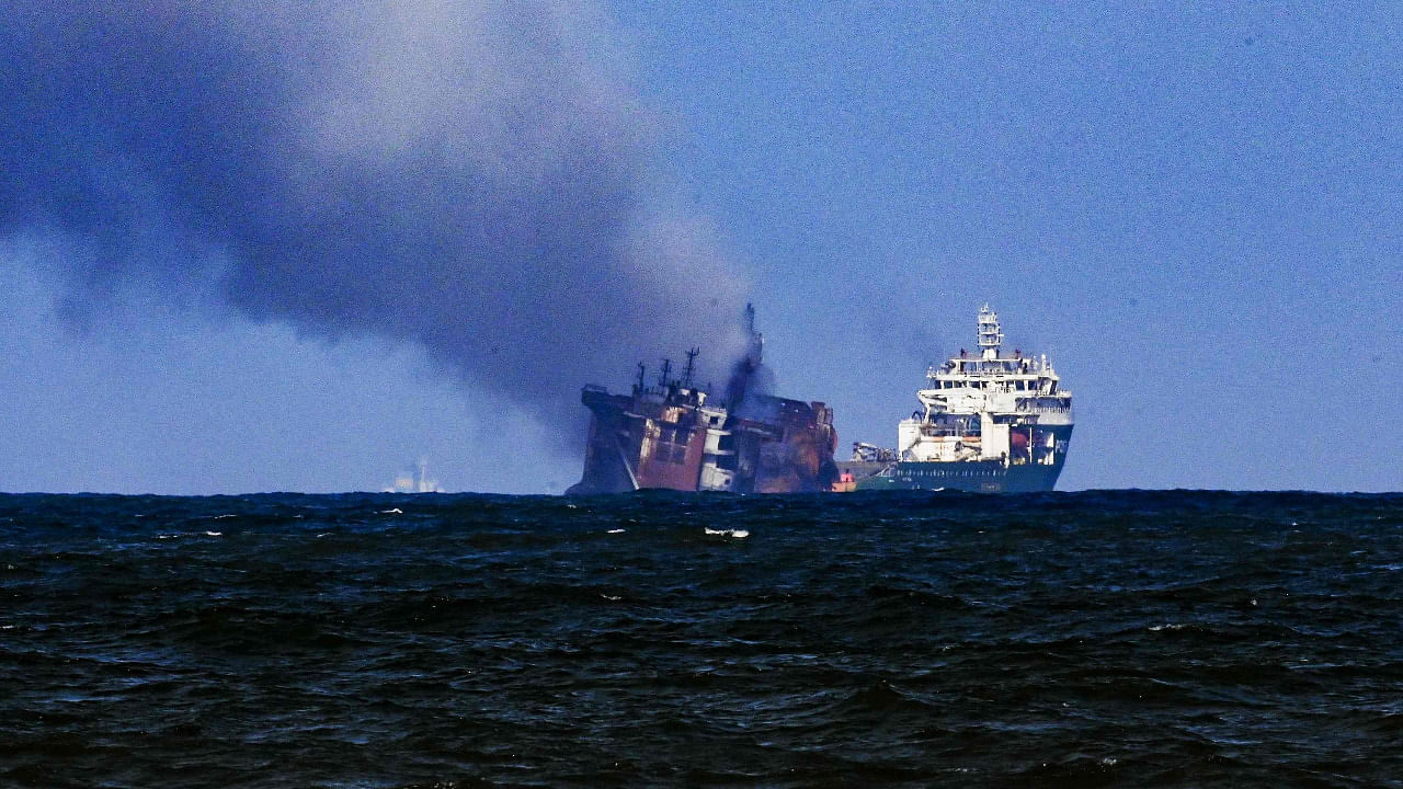 A tugboat (R) from the Dutch salvage firm SMIT tows the fire stricken Singapore-registered container ship MV X-Press Pearl. Credit: AFP Photo