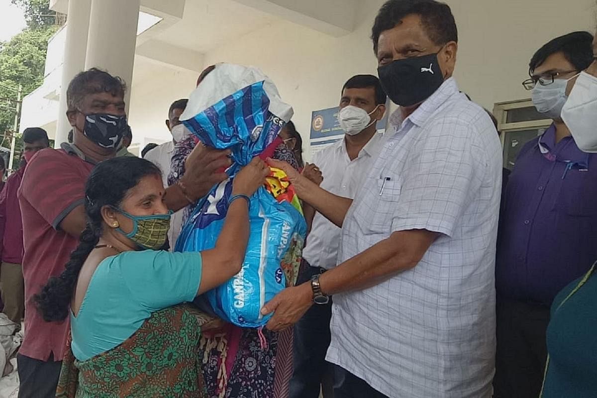 Virajpet MLA K G Bopaiah hands over a food kit to a beneficiary in Virajpet on Tuesday.