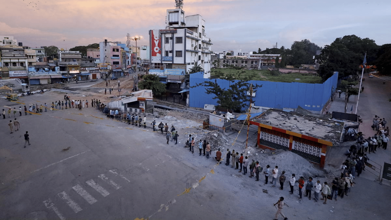 Needy people stand in a queue for free food distributed by volunteers, during Covid-induced lockdown, in Bengaluru. Credit: PTI Photo
