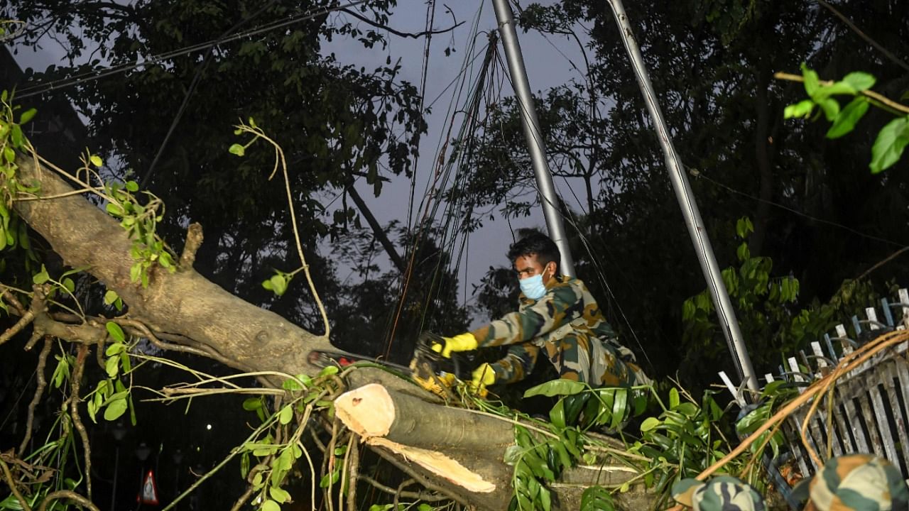 Army personnel deploy to clean roads from fallen tree, electric lines and others following the landfall of cyclone Amphan, in Kolkata on May 23, 2020. Credit: AFP Photo