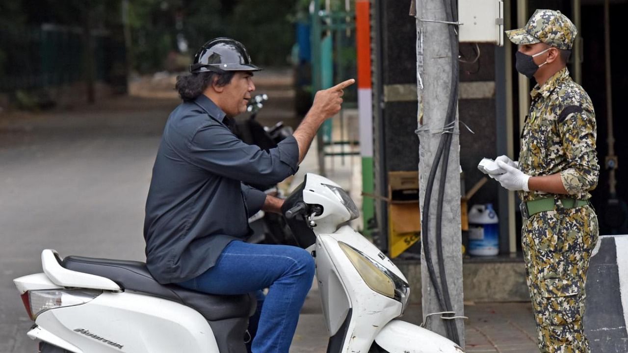 A motorist argues with a marshal after being asked to pay the fine for not wearing a mask in Basavanagudi, Bengaluru. Credit: DH File Photo