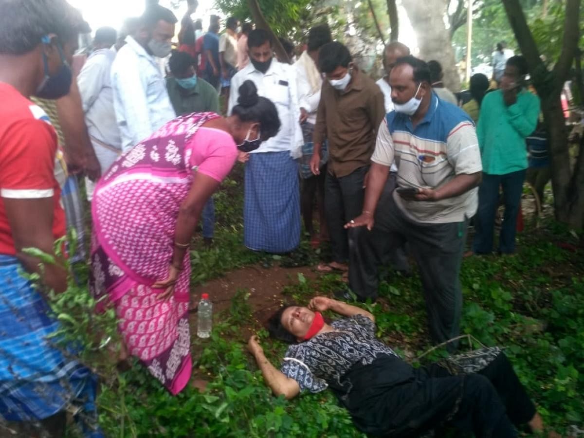 A woman passenger from the car rescued by locals after the mishap, near Halagur, Malavalli taluk, Mandya district, on Friday. DH Photo
