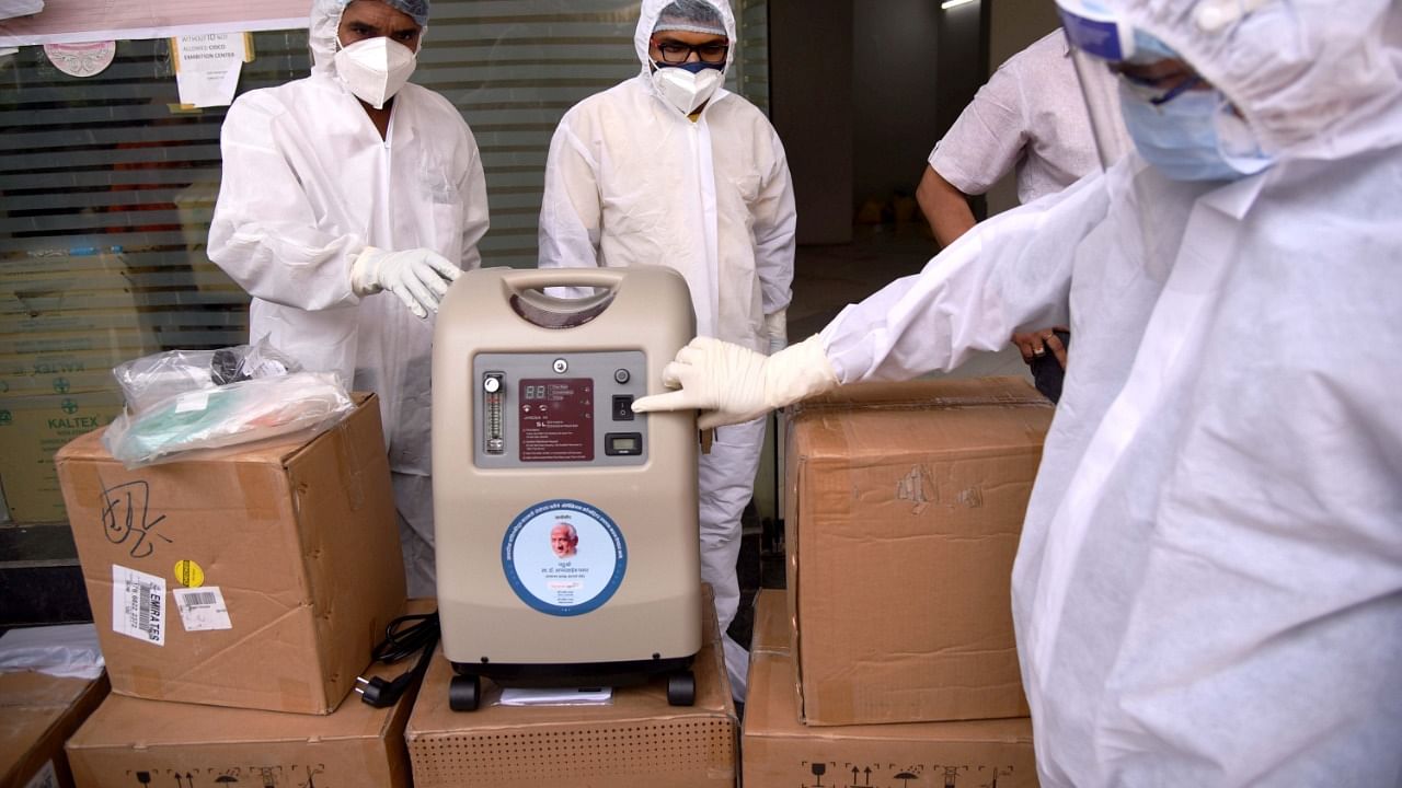 Doctors look at an oxygen concentrator in Mumbai. Credit: PTI File Photo
