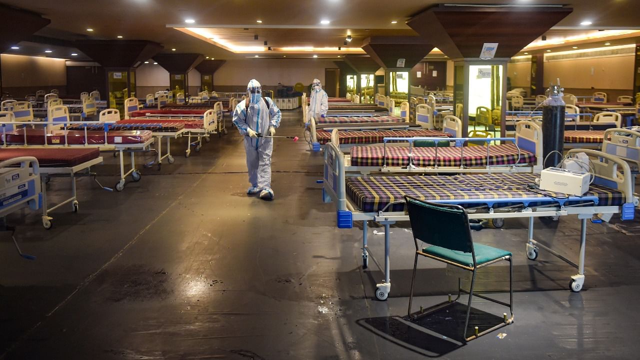 Workers sanitise after all Covid patients were discharged from Shehnai Banquet Hall. Credit: PTI Photo