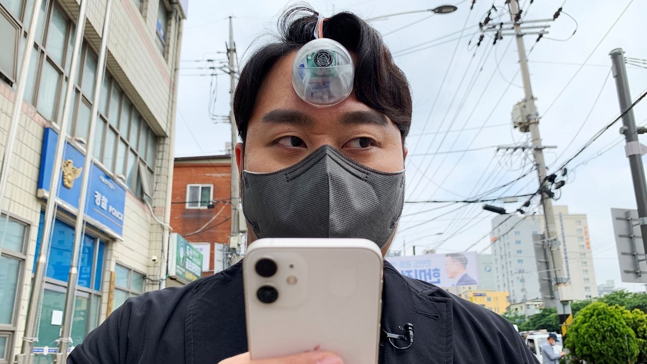 South Korean industrial designer Paeng Min-wook showcases a robotic eye, called "The Third Eye", on his forehead as he uses his mobile phone while walking on street, in Seoul, South Korea, March 31, 2021. Credit: Reuters File Photo