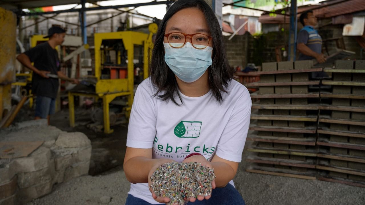 Rebrick founder Novita Tan holding chopped plastic waste. Credit: AFP Photo