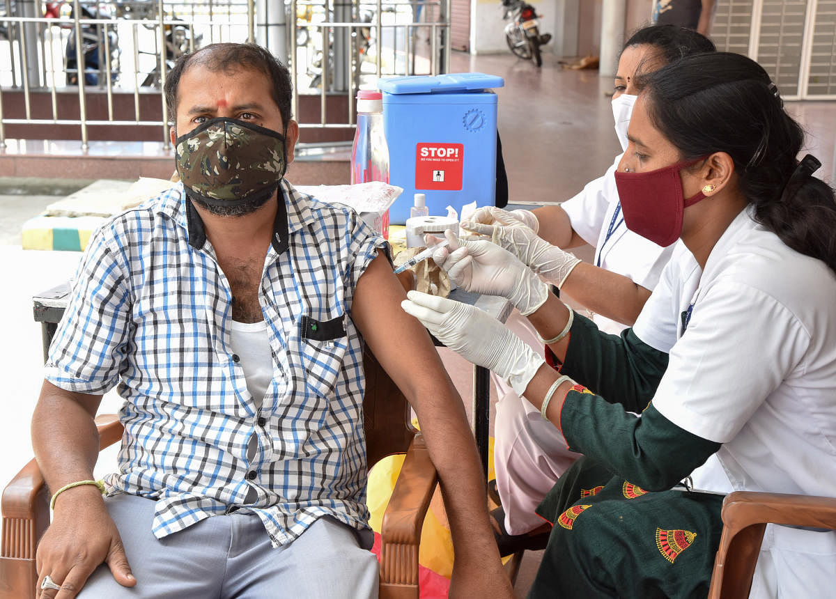 Covid vaccines was administered to autorickshaw and cab drivers at the KSRTC sub-urban bus stand in Mysuru on Friday. DH Photo