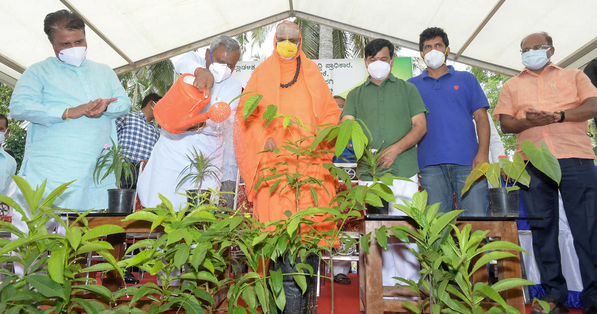 Mysuru District In-charge Minister S T Somashekar inaugurates the programme to hand over 25,000 saplings, by Mysuru City Corporation and Mysuru Urban Development Authority on Saturday, to mark World Environment Day. Seer Shivaratri Deshikendra Swami of Su