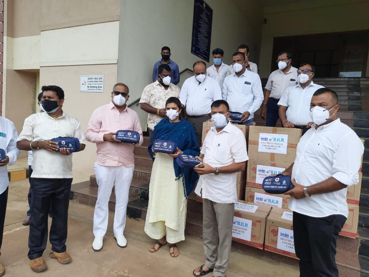 Bommasandra Industries Association (BIA) president Acchapanda Prasad hands over medical kits to Deputy Commissioner Charulata Somal in Madikeri.