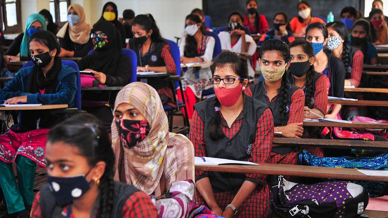 Students wearing face masks attend a class after the authorities reopened schools, amid the coronavirus pandemic, at a government school in Bengaluru. Credit: PTI File Photo