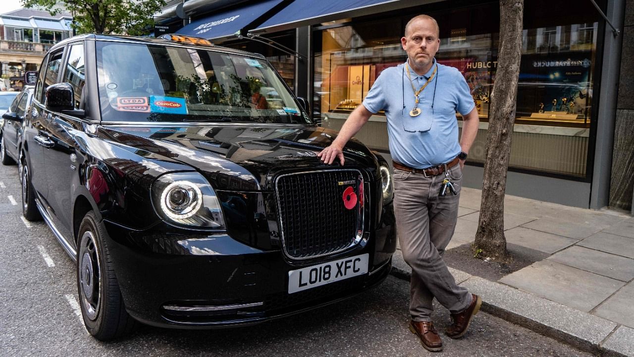 London taxi driver Barry Ivens, 53, poses for a photograph next to his cab in central London. Credit: AFP Photo