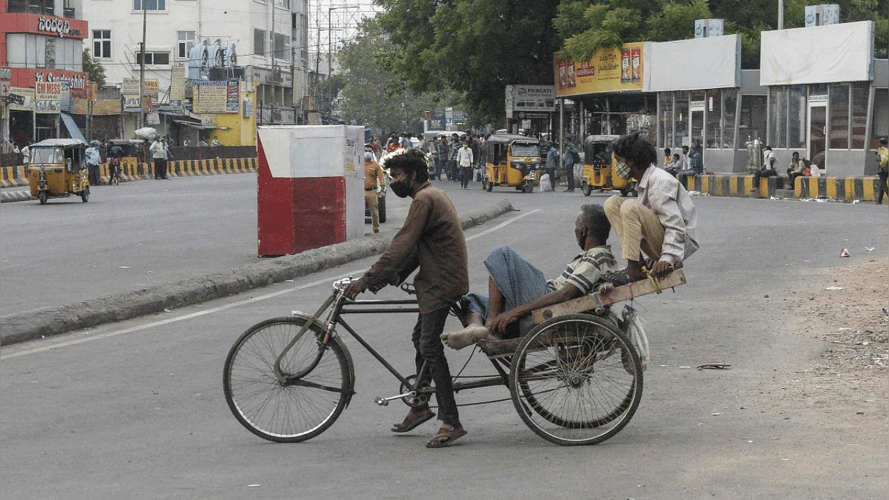 Labourers sit on a rickshaw outside a railway station during a lockdown imposed to curb the spread of the coronavirus, in Secunderabad. Credit: AFP Photo
