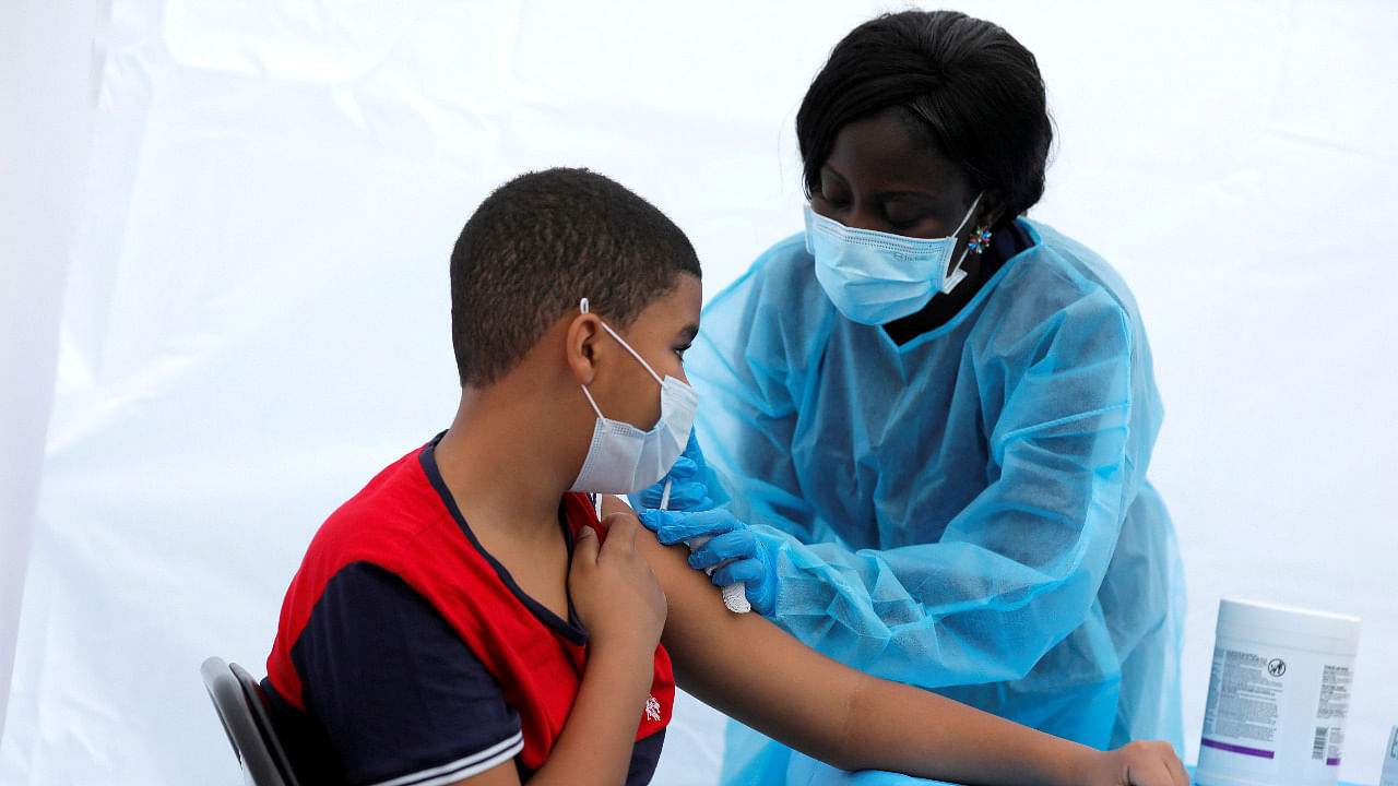 12-year-old Justing Concepcion receives a dose of the Pfizer-BioNTech vaccine in the US. Credit: Reuters Photo