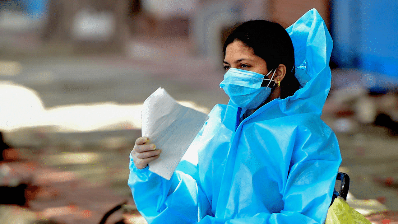  A health worker waits to conduct the Covid-19 test, in Bengaluru. Credit: PTI Photo