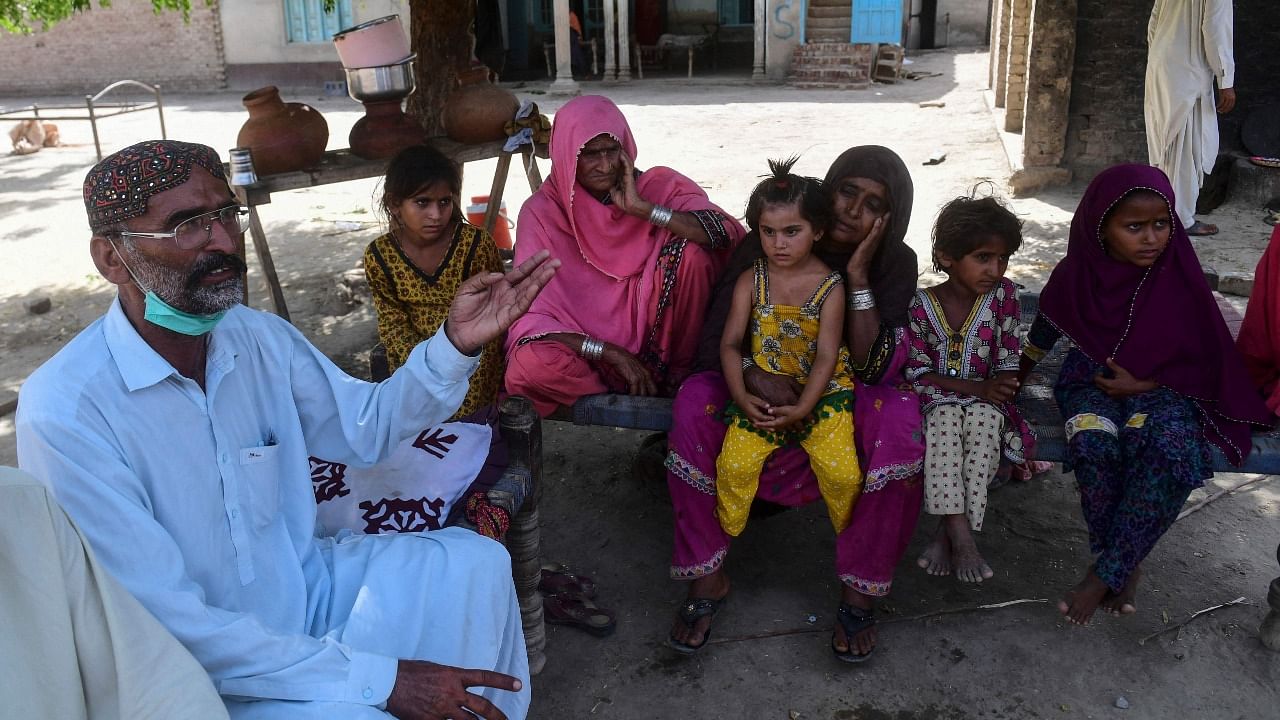 Ali Nawaz (L), who helped with rescue efforts of the train collision, gestures as he sits with his family at his home near the train accident site in Daharki in Sindh Province. Credit: AFP Photo