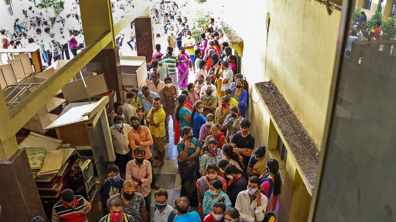 People not adhering to social distancing guidelines wait to receive a ration kit from a government office, amid a coronavirus pandemic, in Bengaluru. Credit: PTI Photo