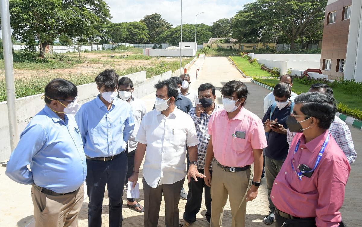 MLA L Nagendra and the officials inspect the laying of the 500 litres per minute (LPM) oxygen generator on the premises of Princess Krishnajammanni Super Specialty Hospital of Mysuru Medical College and Research Institute in Mysuru on Wednesday. DH Photo