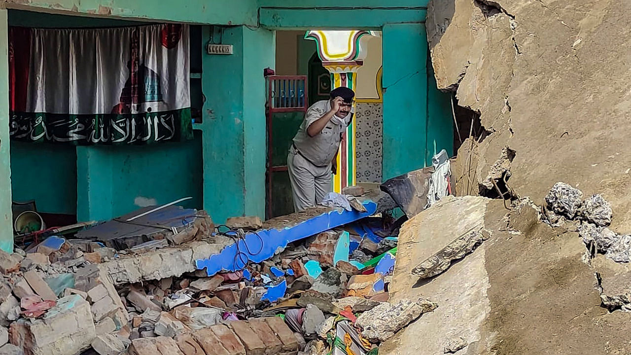 Police official investigates a collapsed Madarasa building after a massive explosion took place, in Banka. Credit: PTI Photo