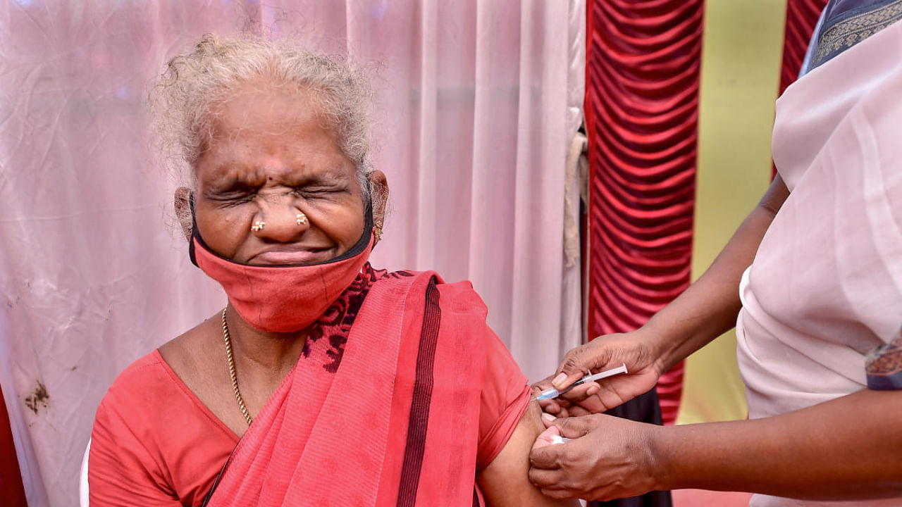 An elderly woman reacts as a health worker administers a dose of the Covid-19 vaccine, at the vaccination centre, in Chennai. Credit: PTI Photo