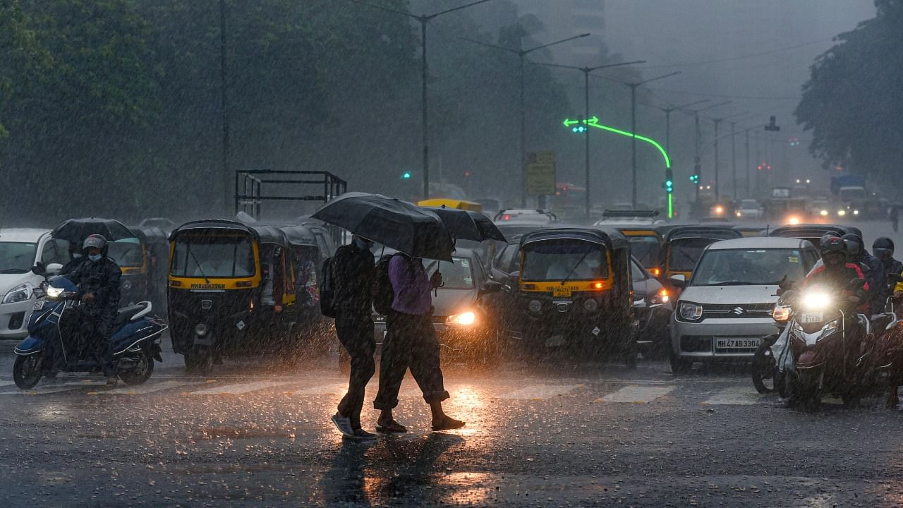 Commuters make their way during heavy rain in Mumbai. Credit: PTI Photo