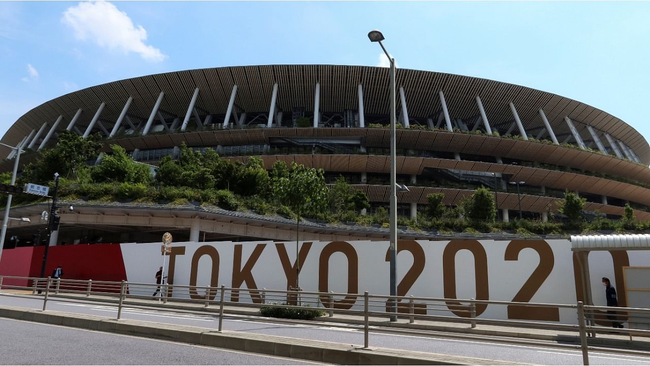 People walk outside the security fence of Olympic Stadium (National Stadium) built for Tokyo Olympic Games. Credit: Reuters Photo
