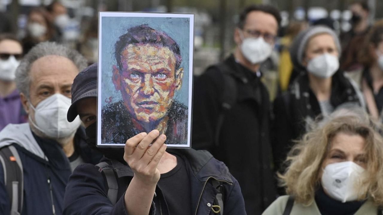 A demonstrator displays a portrait of Kremlin critic Alexei Navalny during a protest. Credit: AFP Photo