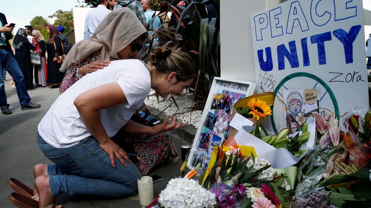 A woman cries next to a tribute to victim Hussein Al-Umari outside Al-Noor mosque after it was reopened in Christchurch. Credit: Reuters Photo