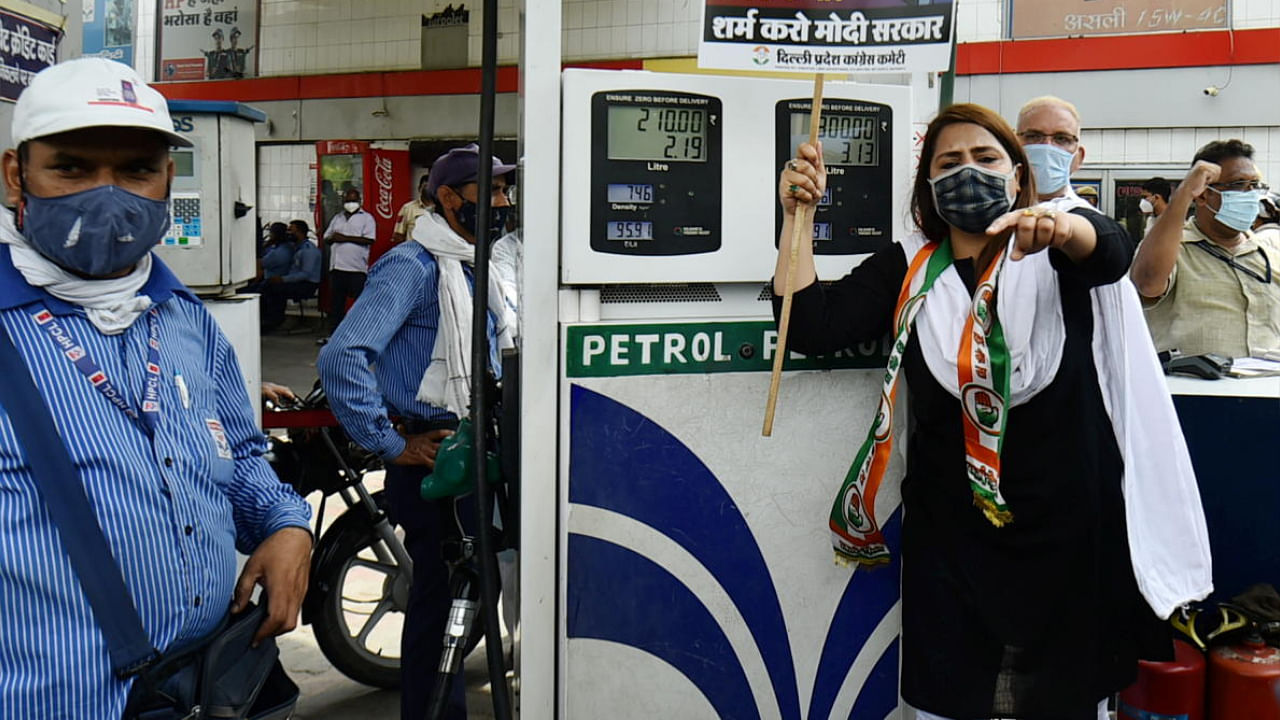 An Indian Youth Congress (IYC) activist holds a placard during their protest against frequent hikes in the prices of petrol and diesel, at Feroz Shah Kotla Stadium Petrol Pump, in New Delhi. Credit: PTI Photo